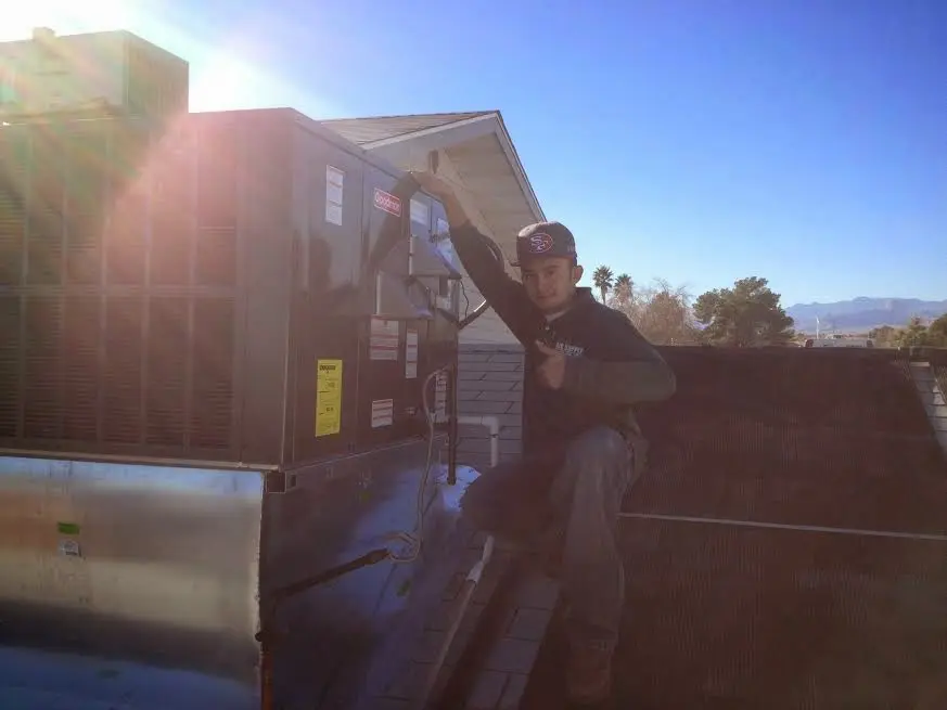 HVAC technician performing AC Tune-Up on a rooftop unit in Lansdale